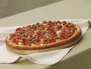 A thin crust pizza covered in meats