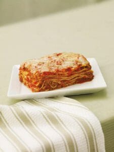 Lasagna on a plate with a green grey background