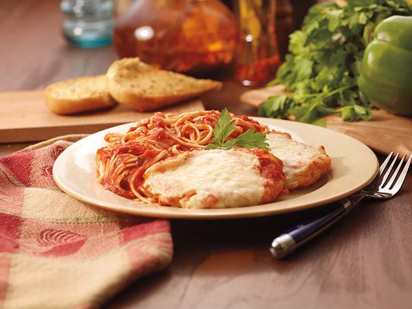 Chicken parmesan on a plate with a napkin and a fork